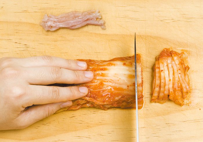 Cắt kimchi và thịt lợn để làm nhân cho bánh kếp cuộn. Có thể cho thêm kimchi củ cải hoặc giá đỗ.